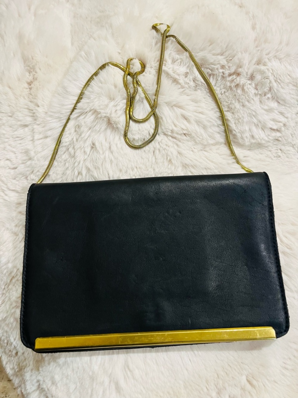 Chic black leather shoulder bag with slinky gold chain